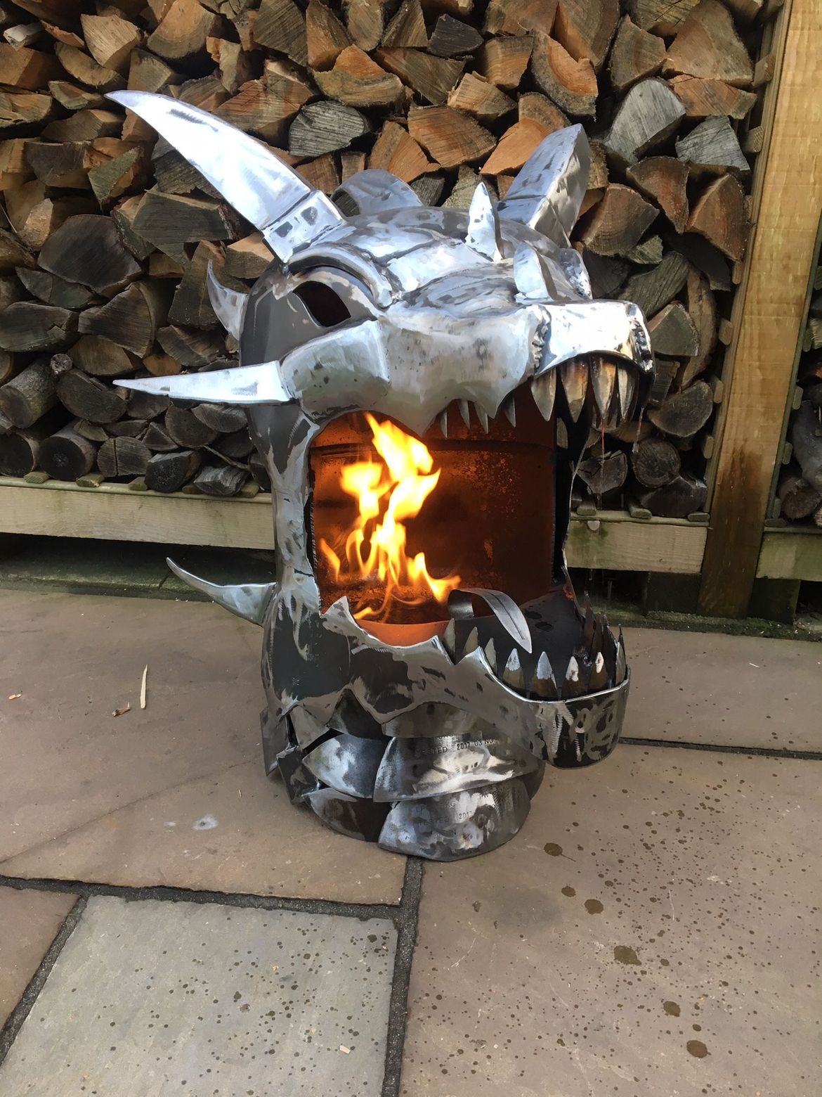 A steel sculpture of a dragon's head turned with flames in its mouth